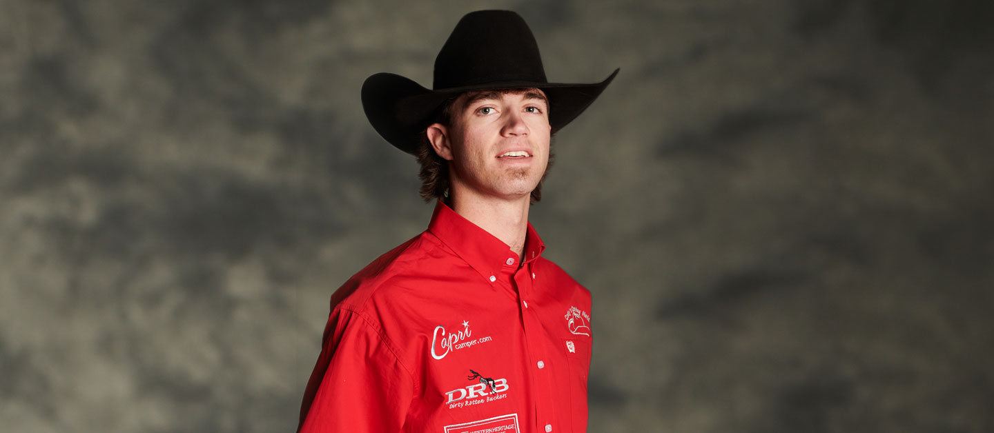 Kade Bruno vistiendo una camisa roja abotonada y un sombrero de vaquero.